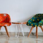 Designerskie, tapicerowane krzesła o różnobarwnej kolorystyce, z drewnianymi nogami.